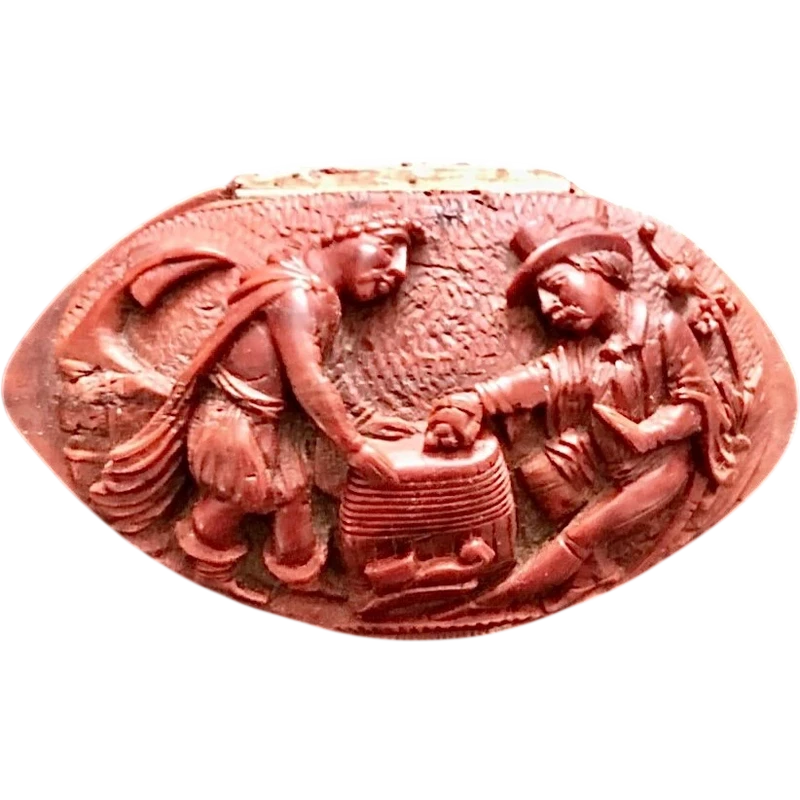 Tabatière une graine de curozo avec une scène de personnage gravée.