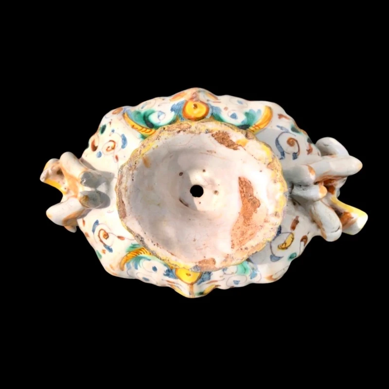 Saliera in maiolica con prese a forma di angeli che reggono dei libri e decoro a ‘raffaellesche