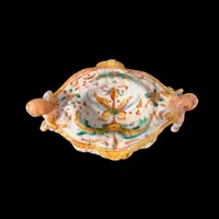 Saliera in maiolica con prese a forma di angeli che reggono dei libri e decoro a ‘raffaellesche