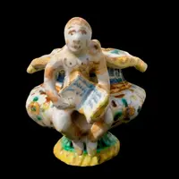 Saliera in maiolica con prese a forma di angeli che reggono dei libri e decoro a ‘raffaellesche