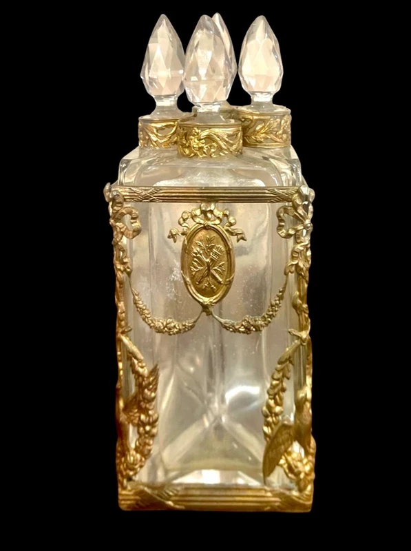 Brass and crystal perfume holder with four small bottles with triangular cross-section.
