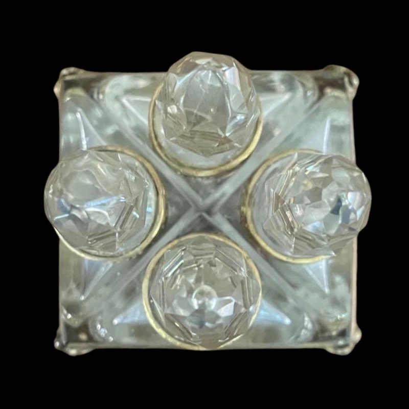 Brass and crystal perfume holder with four small bottles with triangular cross-section.