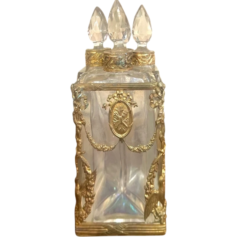 Brass and crystal perfume holder with four small bottles with triangular cross-section.