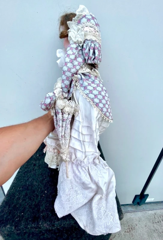 Doll with bisque head and paper mache body.Finely embroidered dress.