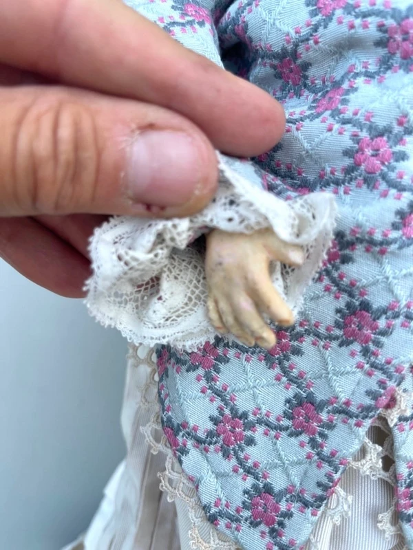 Doll with bisque head and paper mache body.Finely embroidered dress.