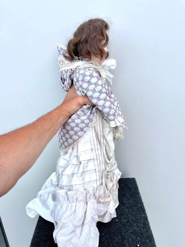 Doll with bisque head and paper mache body.Finely embroidered dress.