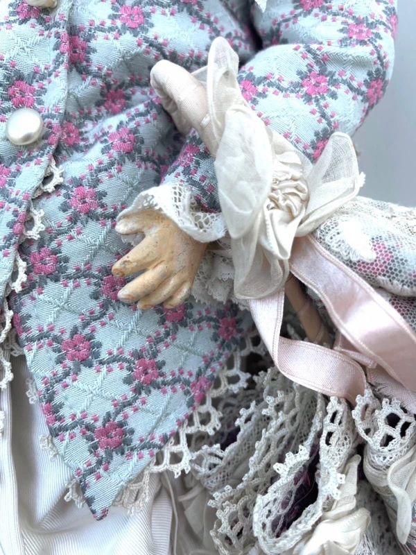 Doll with bisque head and paper mache body.Finely embroidered dress.