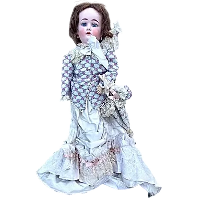 Doll with bisque head and paper mache body.Finely embroidered dress.