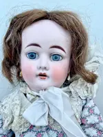 Doll with bisque head and paper mache body.Finely embroidered dress.