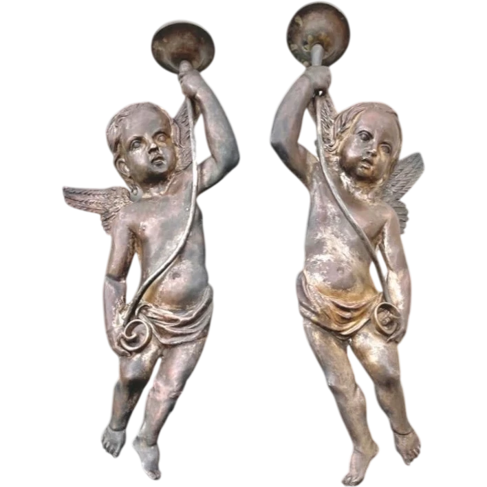 A pair of silver-plated copper wall sconces featuring angels.