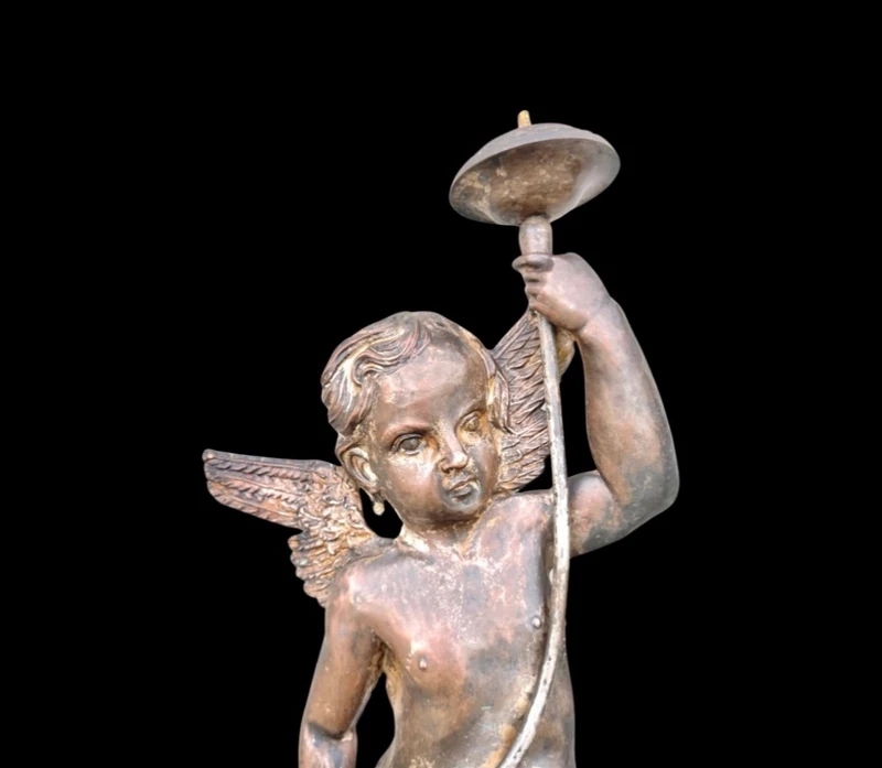 A pair of silver-plated copper wall sconces featuring angels.
