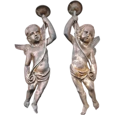 A pair of silver-plated copper wall sconces featuring angels.