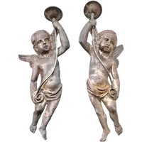 A pair of silver-plated copper wall sconces featuring angels.