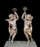 A pair of silver-plated copper wall sconces featuring angels.