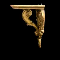 Mensola in legno e foglia oro con festoni ,volute rocaille e motivi vegetali stilizzati.