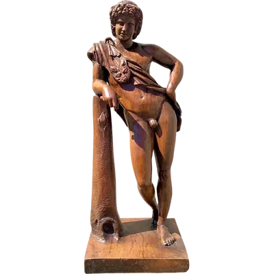 A single-piece wooden sculpture depicting Hercules wearing the lion’s skin. 73 cm (base: 27 x 23 cm).