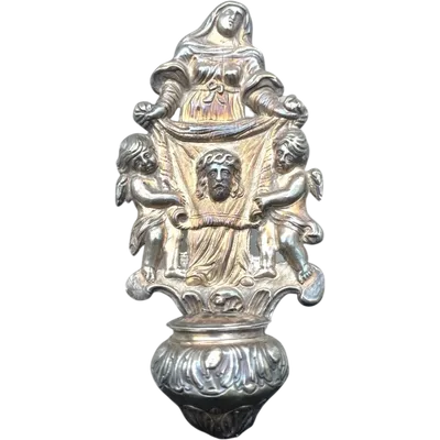 A holy water font made of embossed silver depicting Saint Veronica