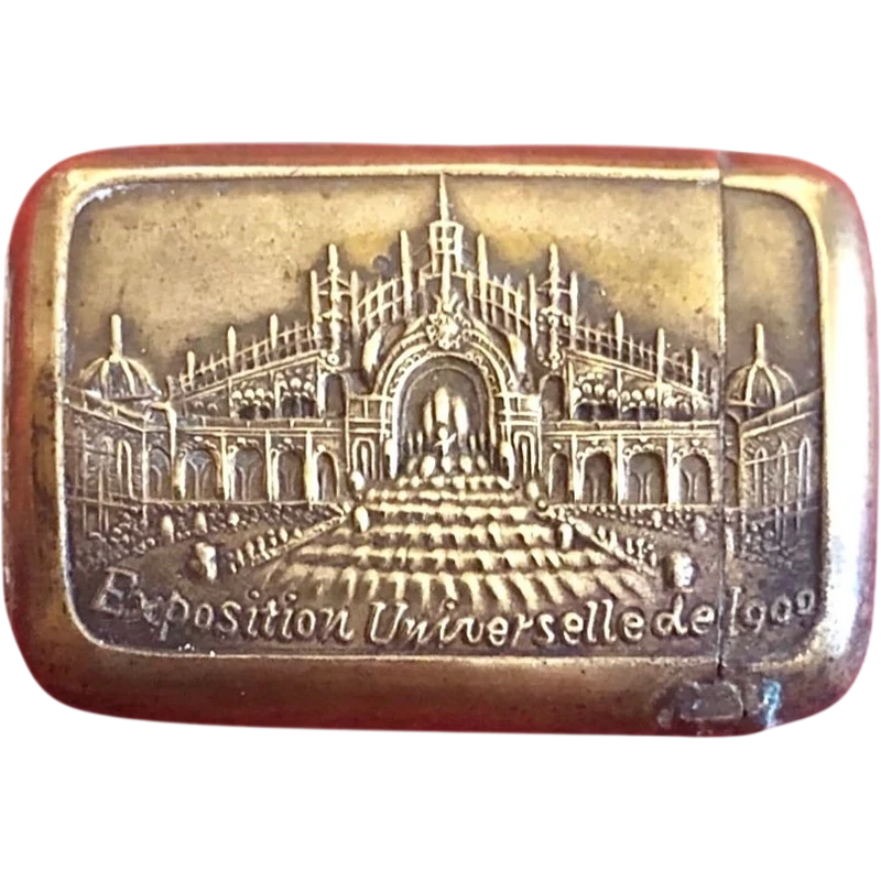 A small brass matchbox depicting the 1900 Paris World’s Fair.