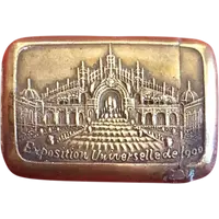 A small brass matchbox depicting the 1900 Paris World’s Fair.