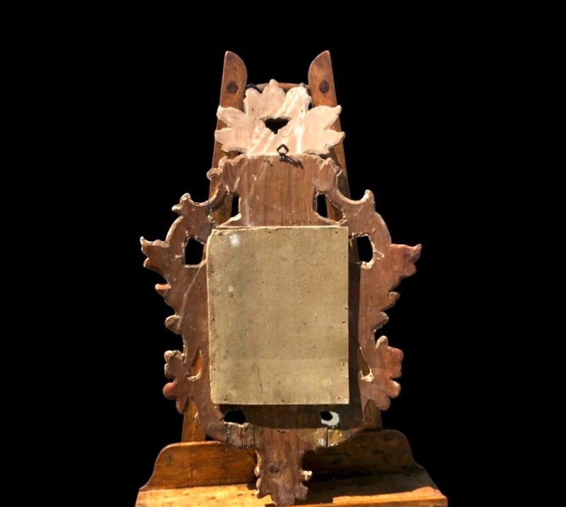 Miroir en bois sculpté avec des motifs végétaux, des motifs rocaille et des feuilles d'or. Venise.