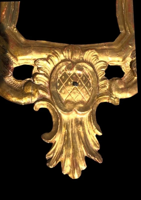 Miroir en bois sculpté avec des motifs végétaux, des motifs rocaille et des feuilles d'or. Venise.