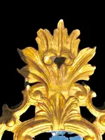 Miroir en bois sculpté avec des motifs végétaux, des motifs rocaille et des feuilles d'or. Venise.