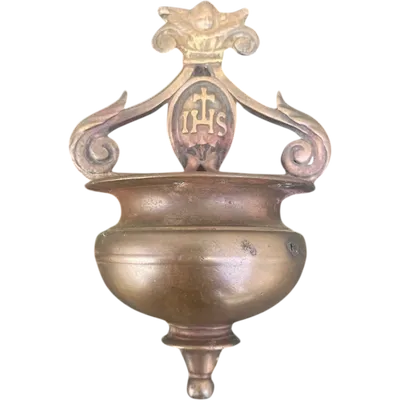 Bronze holy water font with an outward-curving rim, scroll-shaped handles, and a cherub