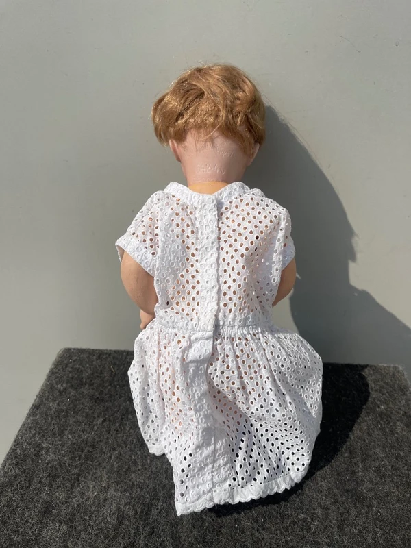 Poupée avec une tête en biscuit, des yeux mobiles et un corps en papier mâché. Signée Heuback, Allemagne.