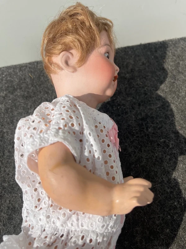 Poupée avec une tête en biscuit, des yeux mobiles et un corps en papier mâché. Signée Heuback, Allemagne.