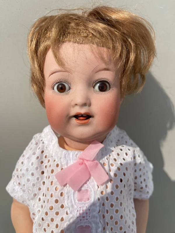 Poupée avec une tête en biscuit, des yeux mobiles et un corps en papier mâché. Signée Heuback, Allemagne.