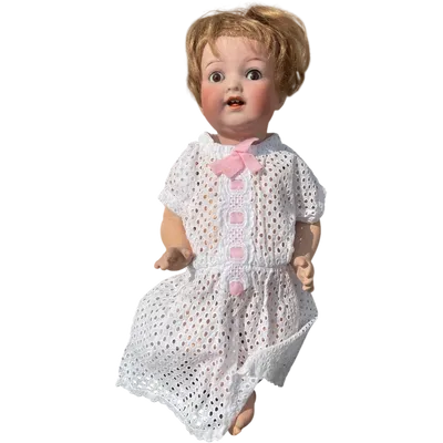 Doll with a bisque head, movable eyes, and a papier-mâché body. Signed Heuback, Germany.