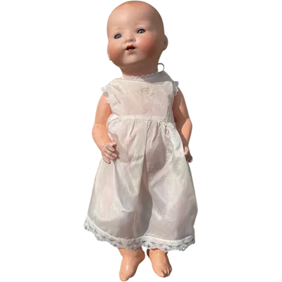 Bébé Caractère doll with a bisque head, movable eyes, and a papier-mâché body.