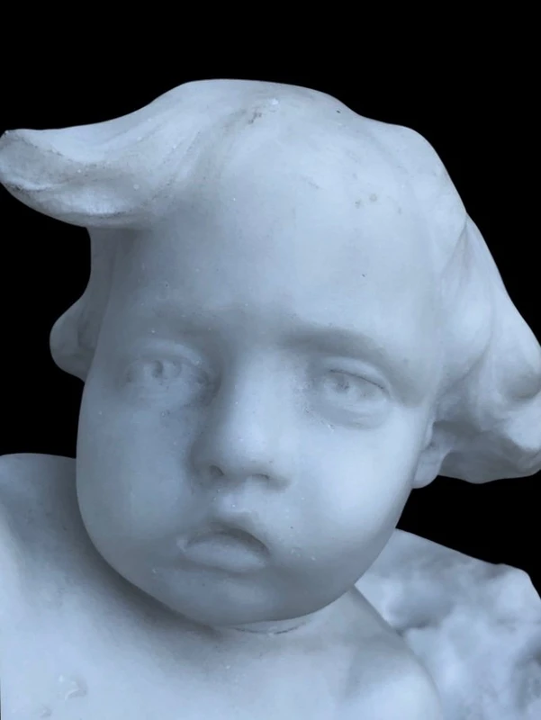 Sculpture en marbre blanc de Carrare représentant un enfant avec un papillon.