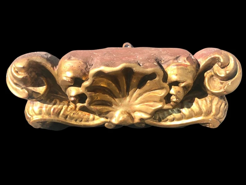 Mensola-applique in legno intagliato e foglia oro con decoro rocaille e conchiglia.