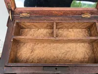 Boîte en forme de coffre en noyer, dotée de compartiments et d'un miroir à l'intérieur.