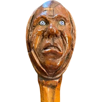 Cane with a curozo seed knob depicting a grotesque face. Glass eyes