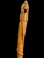 Canne traditionnelle en bois d'une seule pièce, sculptée d'un jaguar attaquant un serpent.