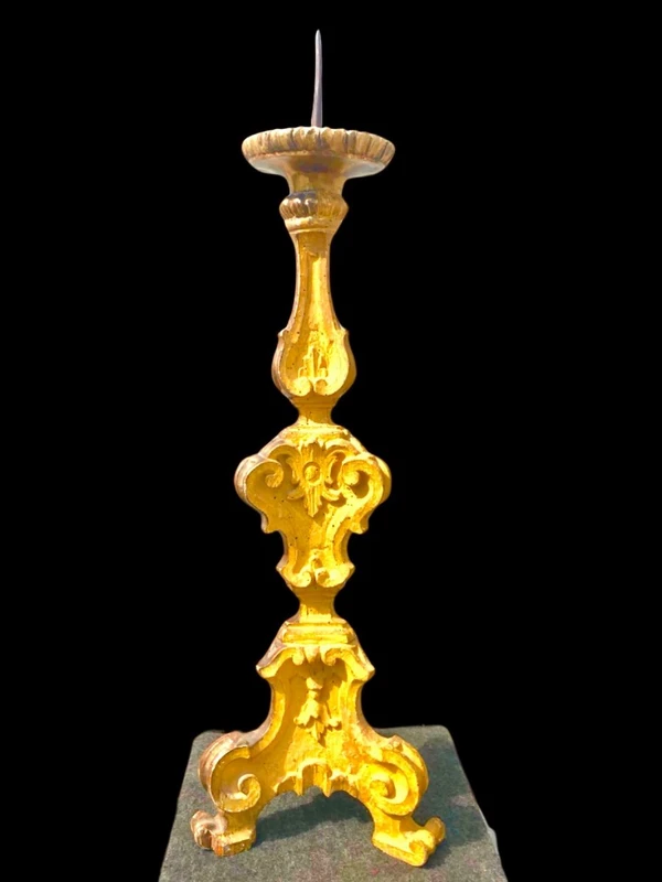 Candeliere in legno intagliato e dorato a mecca con motivi rocaille e vegetali stilizzati .