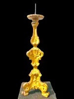 Candeliere in legno intagliato e dorato a mecca con motivi rocaille e vegetali stilizzati .