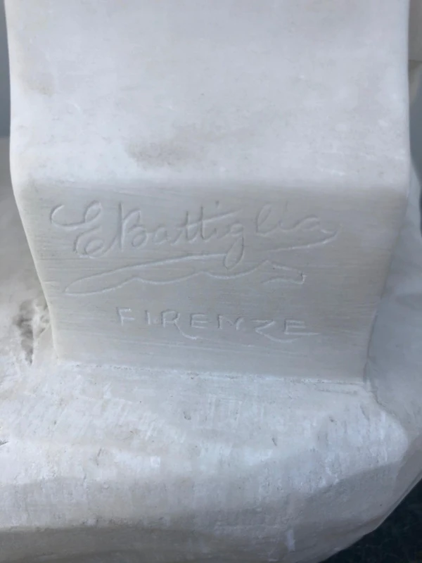 A sculpture in white Carrara marble depicting a mother holding cherries and her child.