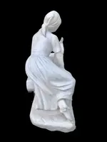 A sculpture in white Carrara marble depicting a mother holding cherries and her child.