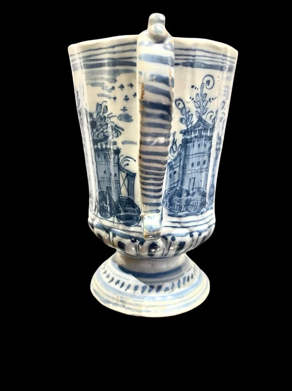 Majolica pitcher with a three-lobed spout, a handle featuring a serpentine motif, and a globular body