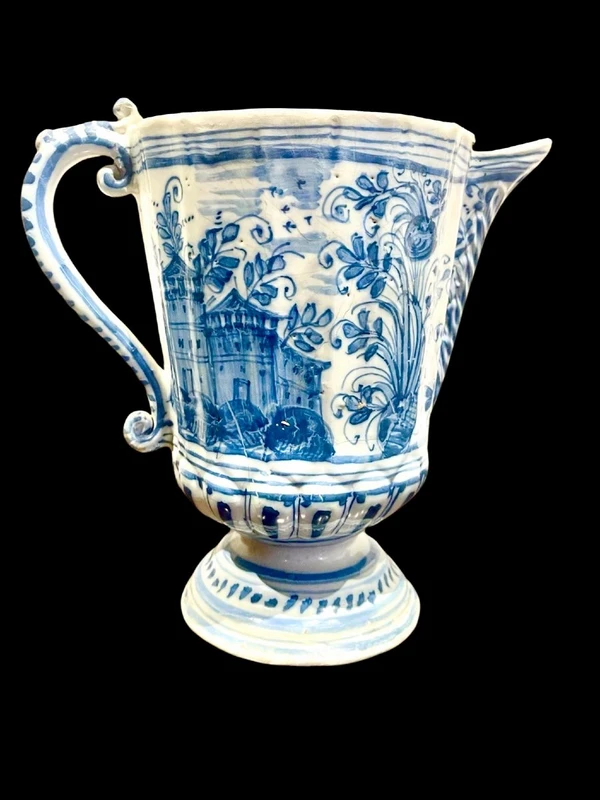Majolica pitcher with a three-lobed spout, a handle featuring a serpentine motif, and a globular body
