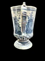 Majolica pitcher with a three-lobed spout, a handle featuring a serpentine motif, and a globular body