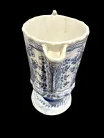 Majolica pitcher with a three-lobed spout, a handle featuring a serpentine motif, and a globular body