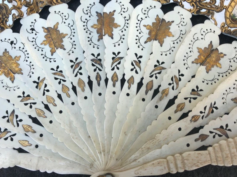 Fan with openwork, gilded bone ribs. Paper cover with watercolor prints