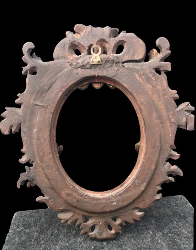 Carved and gilded wooden frame with a "cartoccio" finish.
