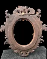Carved and gilded wooden frame with a "cartoccio" finish.