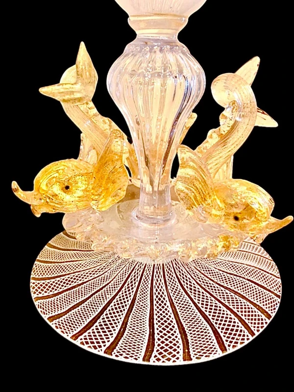 A bowl-shaped vase made of zanfirico glass with gold inclusions, featuring three dolphins on the base. Fratelli Toso.