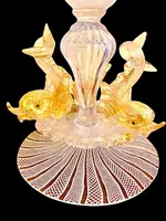 A bowl-shaped vase made of zanfirico glass with gold inclusions, featuring three dolphins on the base. Fratelli Toso.